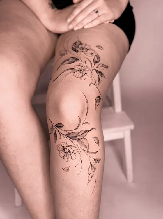 Fine line botanical tattoo on the knee by Ingrid Campelo